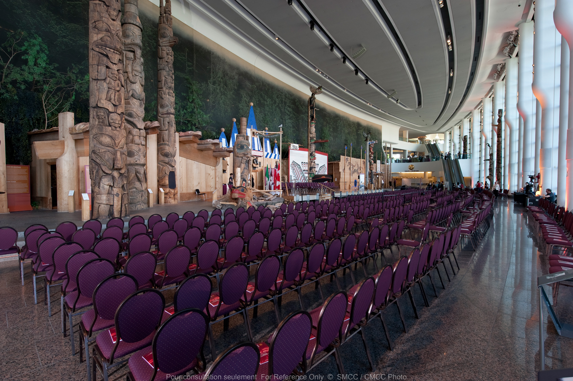 A large auditorium with purple chairs facing a stage.