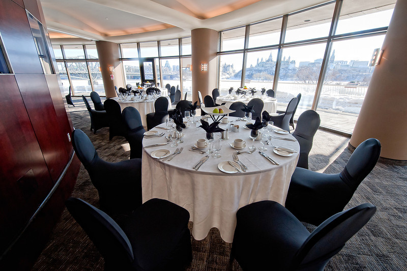 A table set up with black chairs and a view of the city.