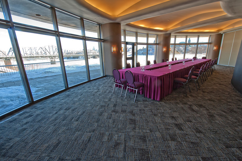 A conference room with large windows and a pink tablecloth.