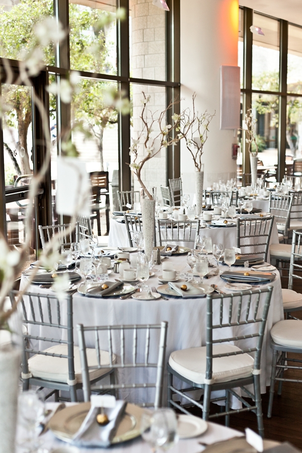 A room with tables and chairs set up for a wedding reception.