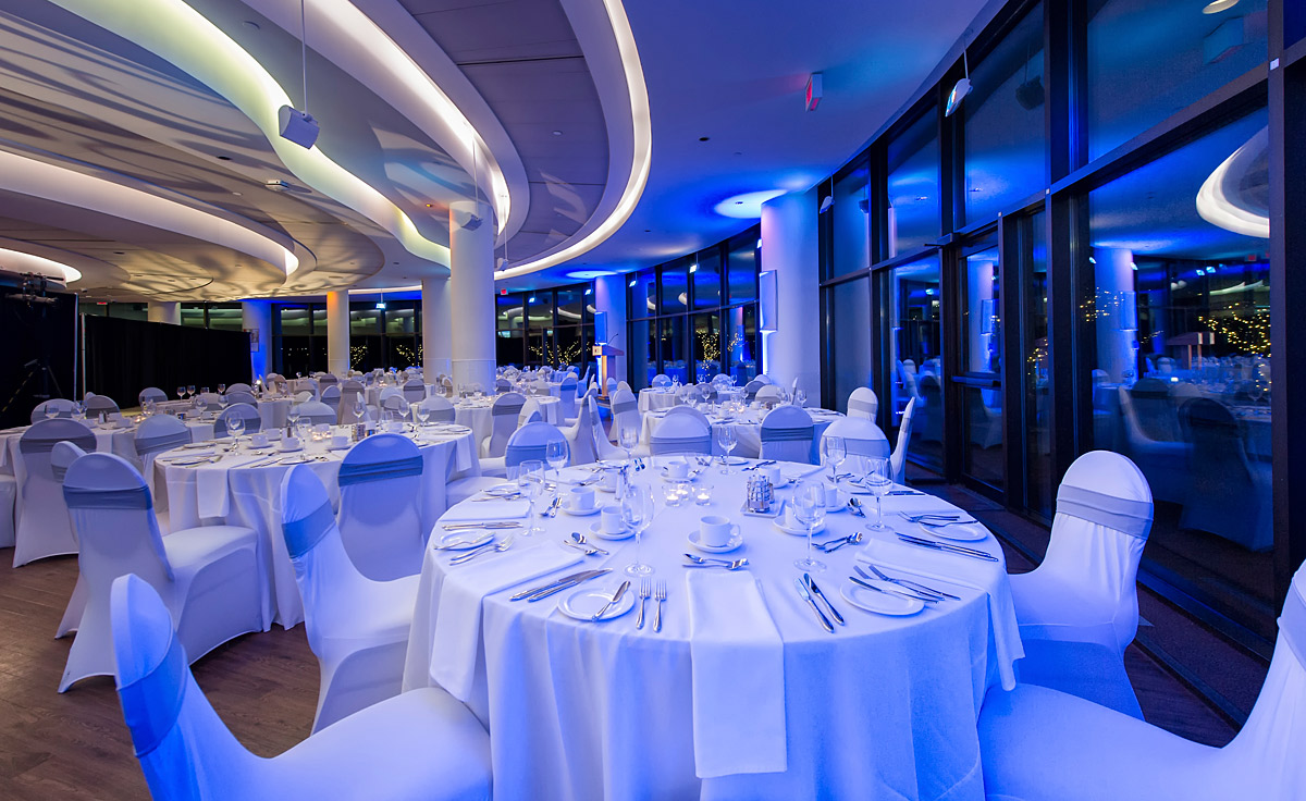 Le Musée canadien de l'histoire à Ottawa présente une salle de banquet à couper le souffle ornée de tables blanches et rehaussée de lumières bleues fascinantes.