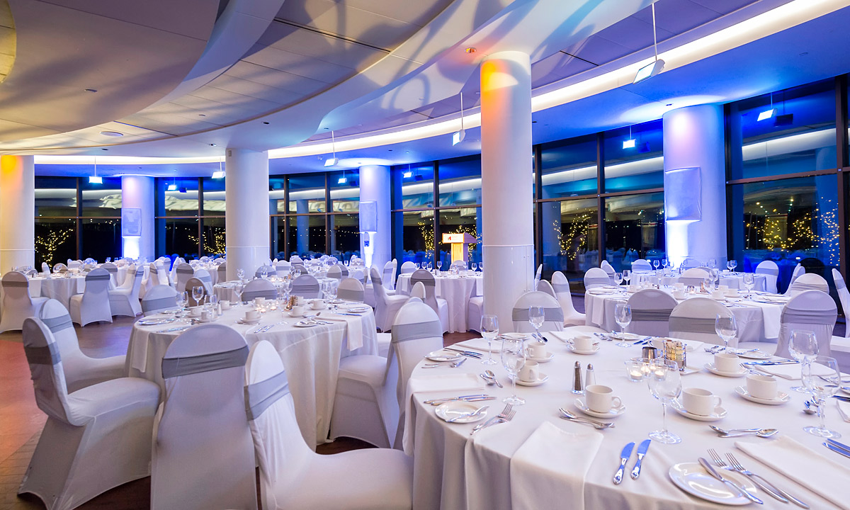 Une grande salle de banquet avec des tables et des chaises blanches située à Ottawa au Musée canadien de l'histoire.