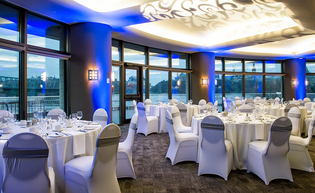 Une grande salle avec tables et chaises aménagées pour un mariage au Musée canadien de l'histoire à Ottawa.