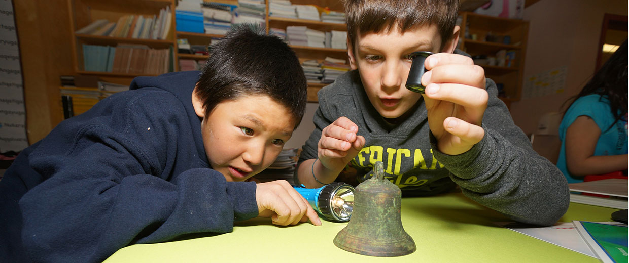 Deux garçons regardant une cloche au Musée canadien de l'histoire.