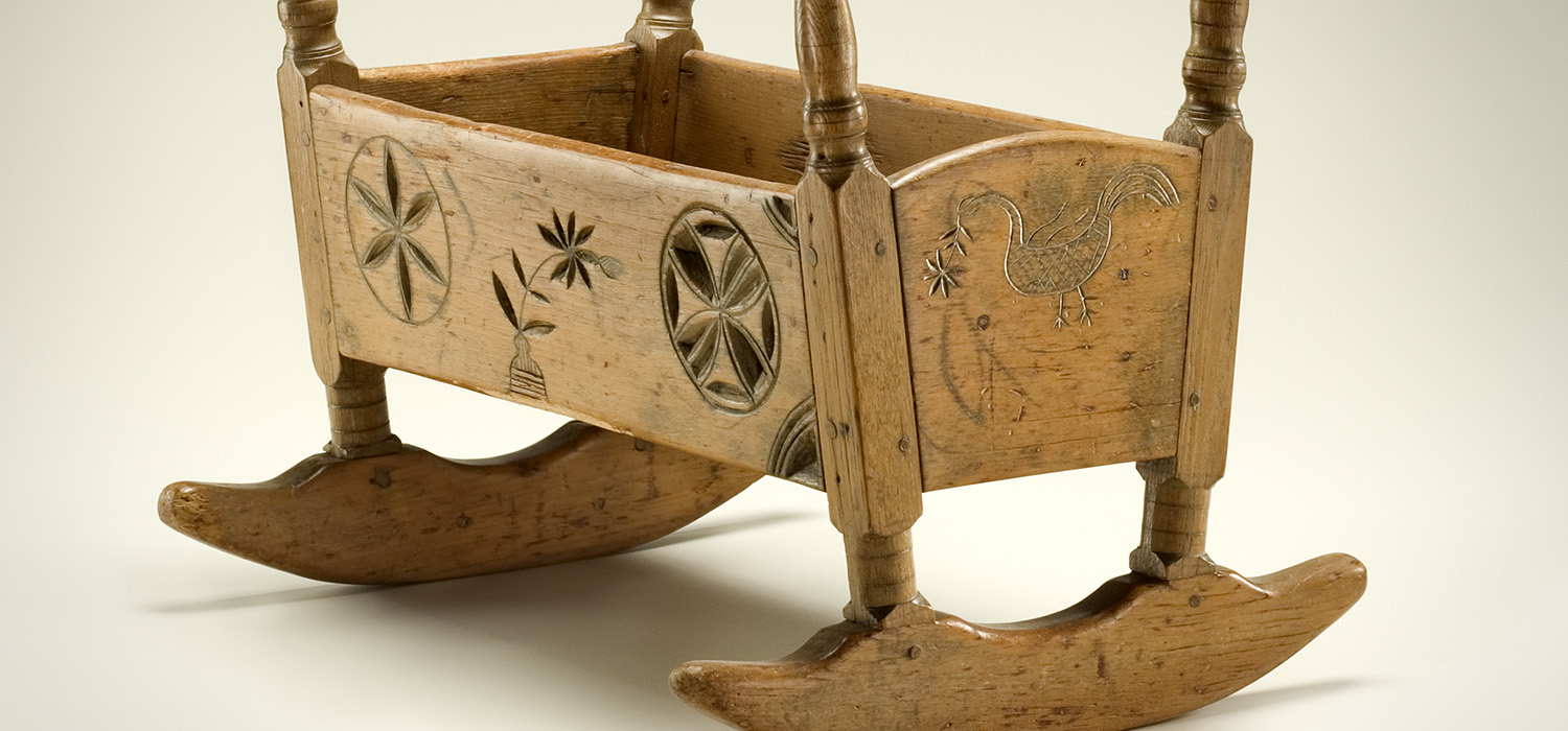 Une chaise berçante en bois avec des sculptures exposées au Musée canadien de l'histoire à Ottawa.