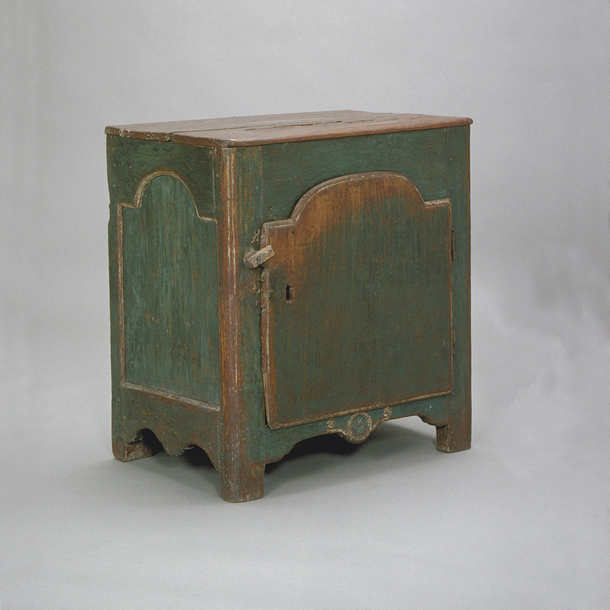 Une petite armoire verte avec une porte en bois située à Ottawa au Musée canadien de l'histoire.