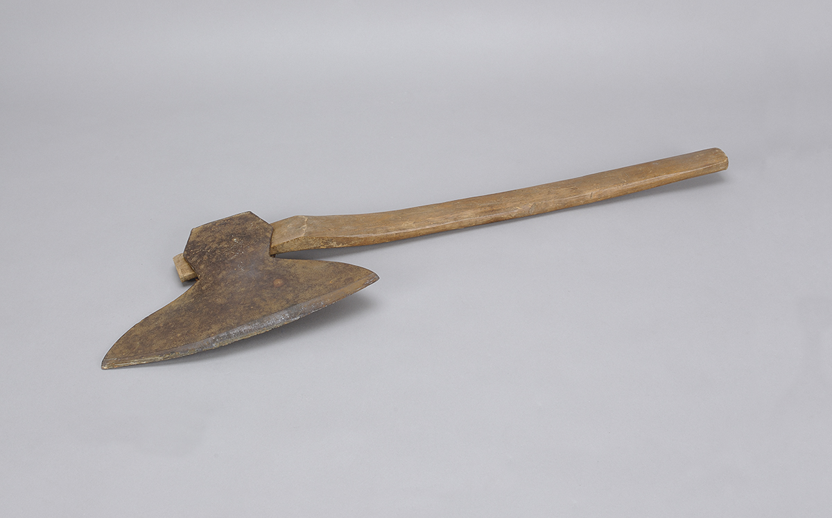 Une hache avec un manche en bois sur fond blanc, exposée au Musée canadien de l'histoire à Ottawa.