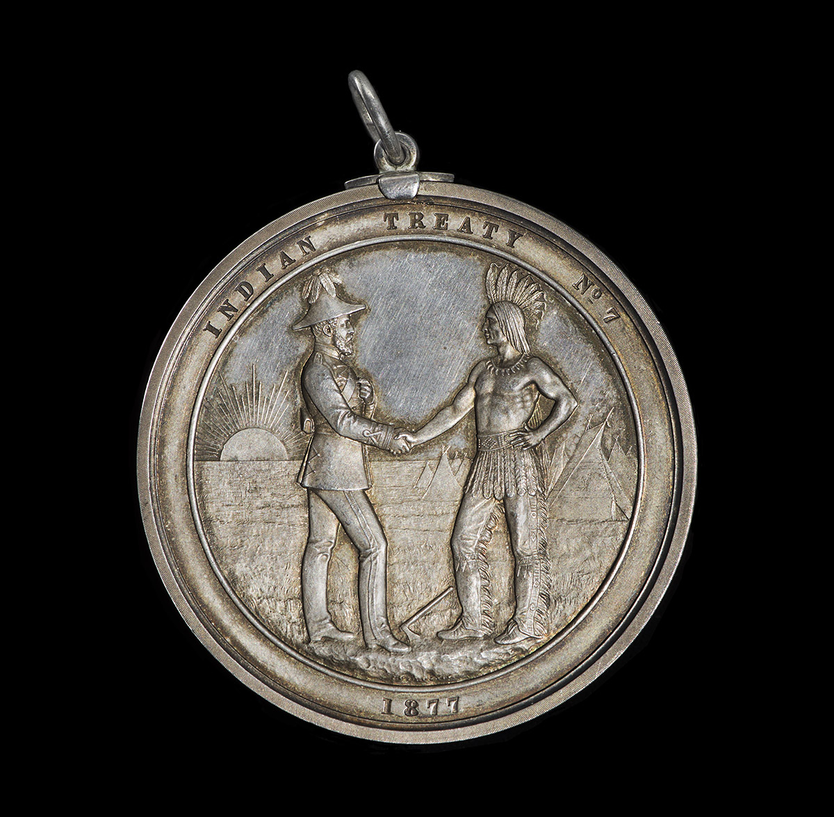 Une médaille d'argent avec deux hommes se serrant la main exposée au Musée canadien de l'histoire à Ottawa.