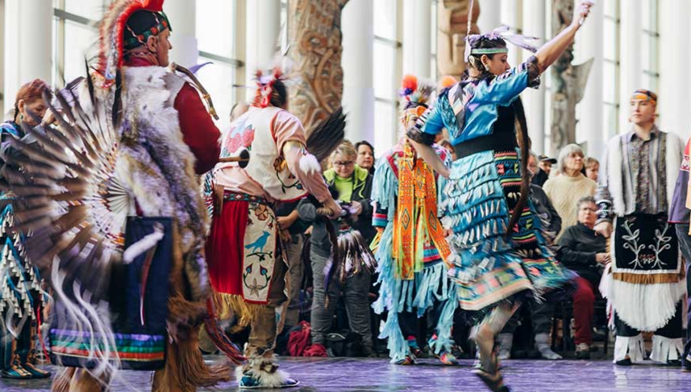 Un groupe de danseurs amérindiens se produisant devant un public au Musée canadien de l'histoire à Ottawa.