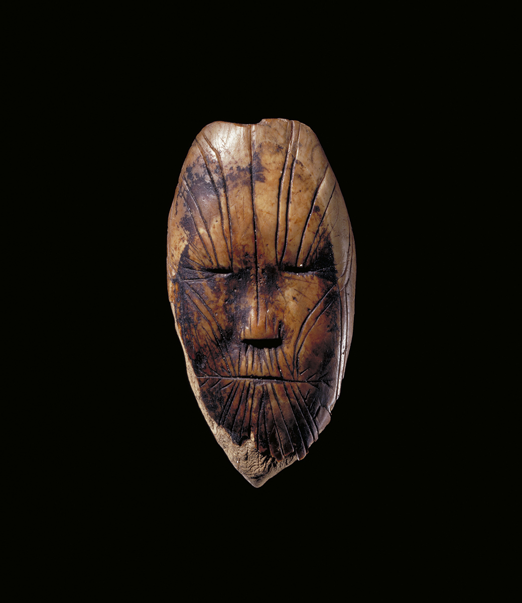 Un masque en bois sur fond noir exposé au Musée canadien de l'histoire à Ottawa.