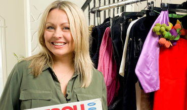 woman holding sale sign infront of clothing rack