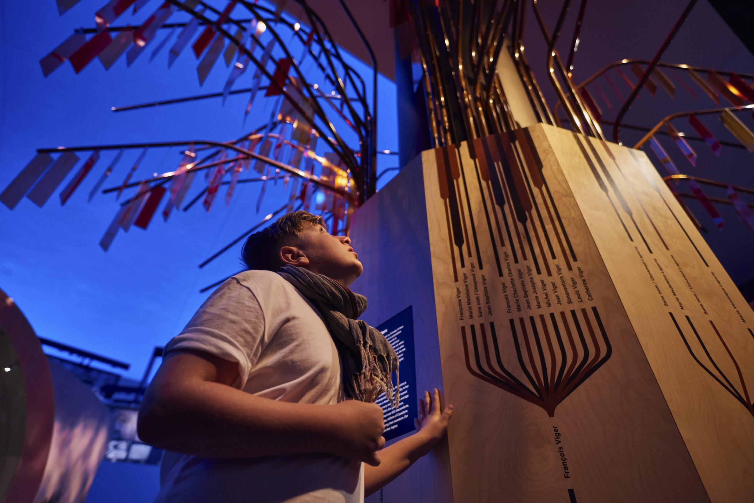 Un jeune garçon à Ottawa, au Canada, regardant une grande structure en bois à l'intérieur du Musée canadien de l'histoire.