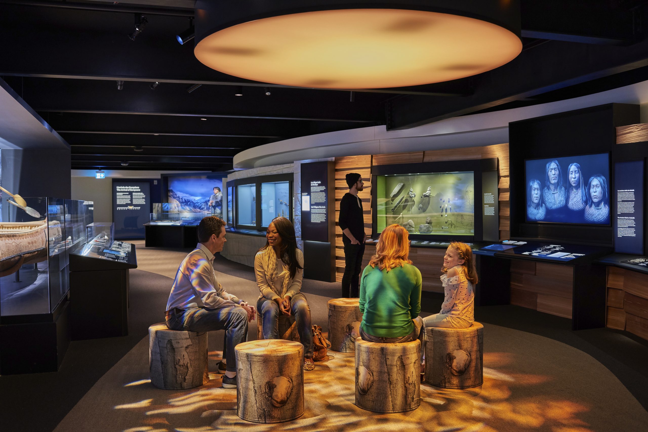 Un groupe de personnes est assis dans l'exposition du Musée canadien de l'histoire à Ottawa.