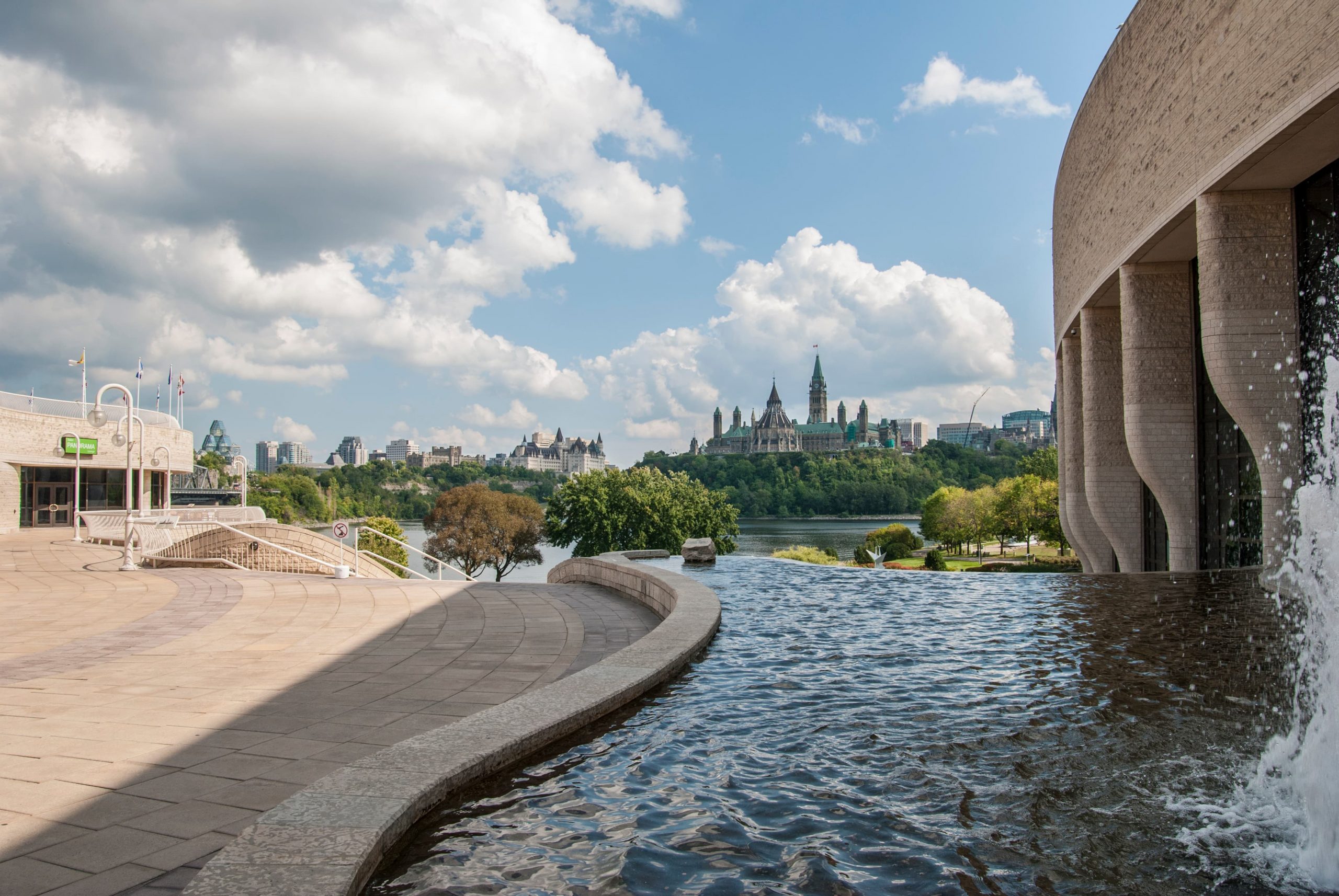 Une fontaine devant le Musée canadien de l'histoire avec une ville en arrière-plan.