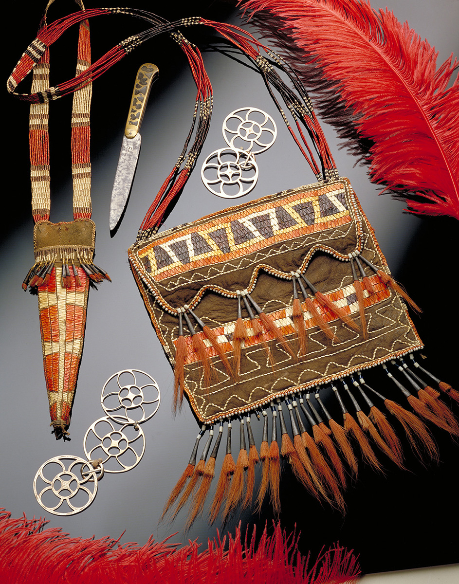 Un sac à main avec des plumes et un couteau sur une surface noire au Musée canadien de l'histoire.