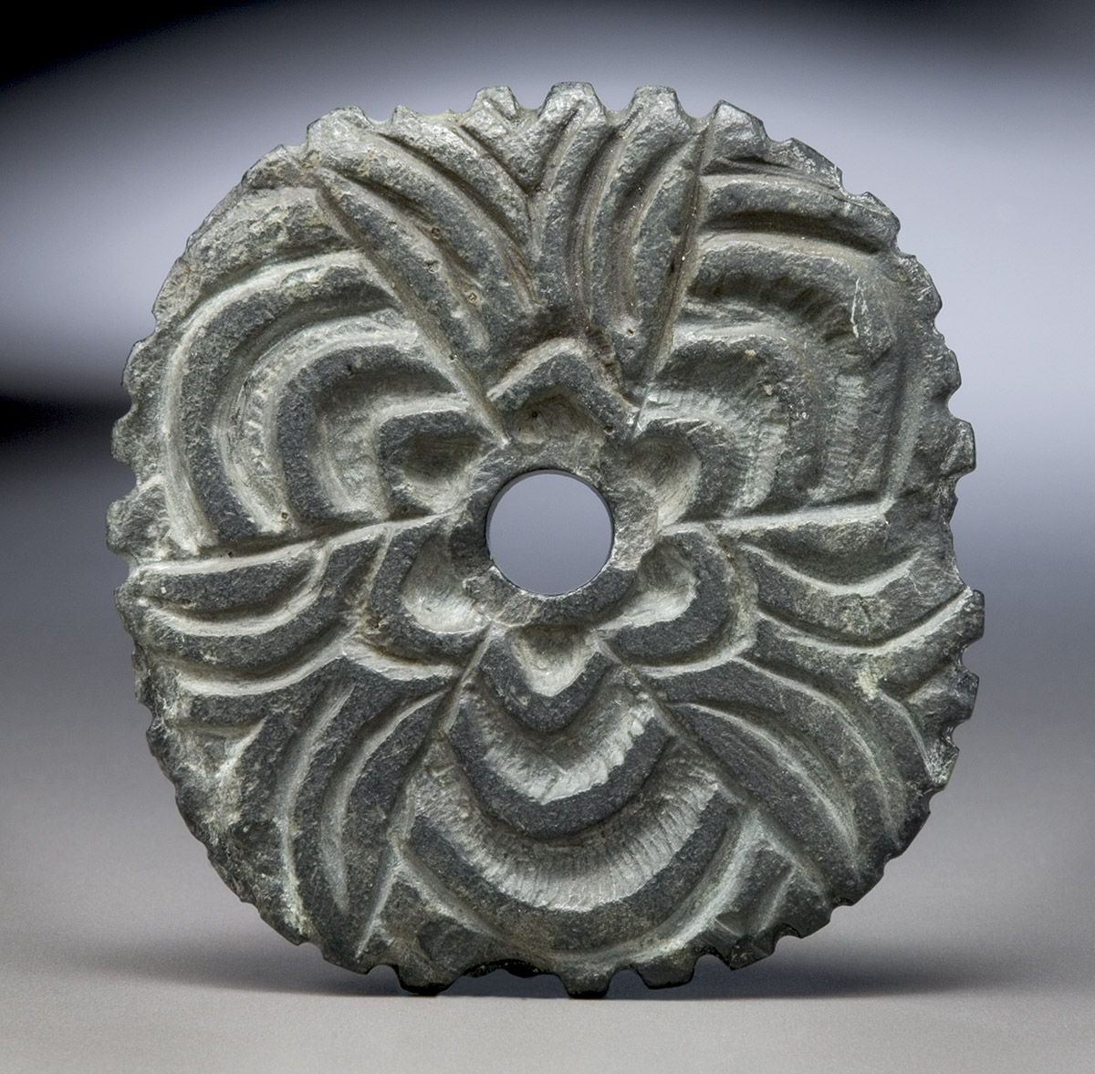 Un disque en bronze orné d'une fleur, conservé au Musée canadien de l'histoire à Ottawa.