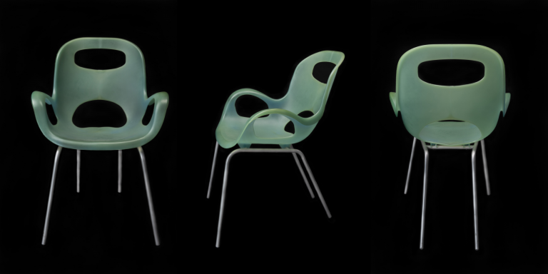 A modern green plastic armchair with steel legs.