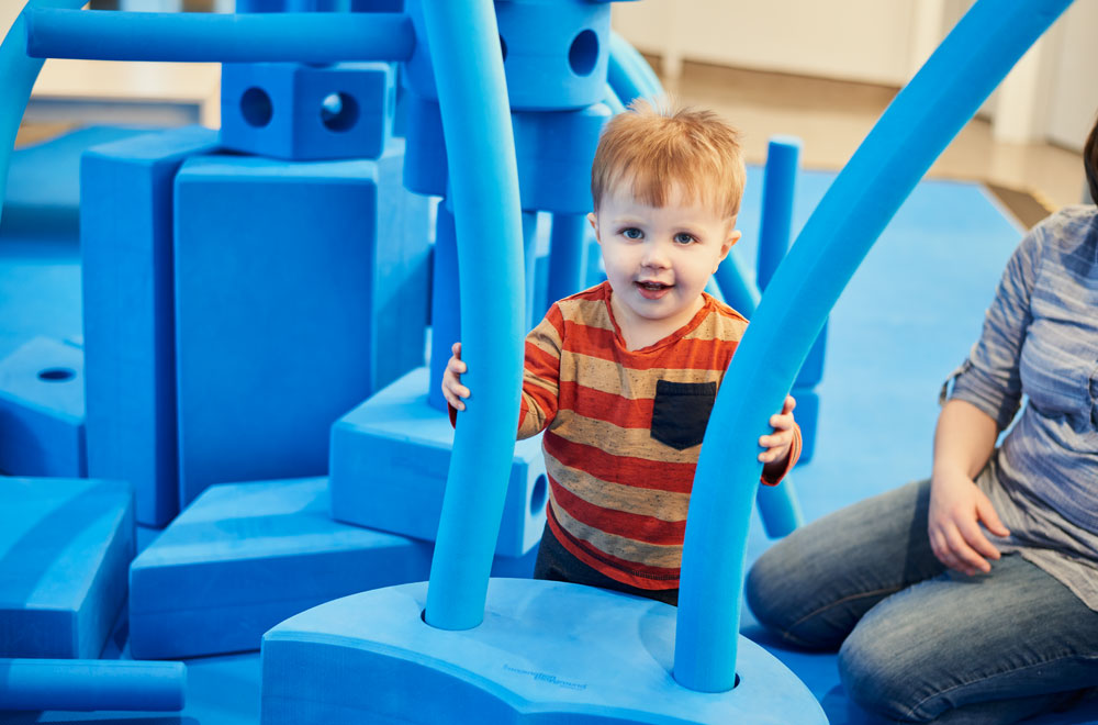 Enfant avec d’immenses morceaux de mousse bleus