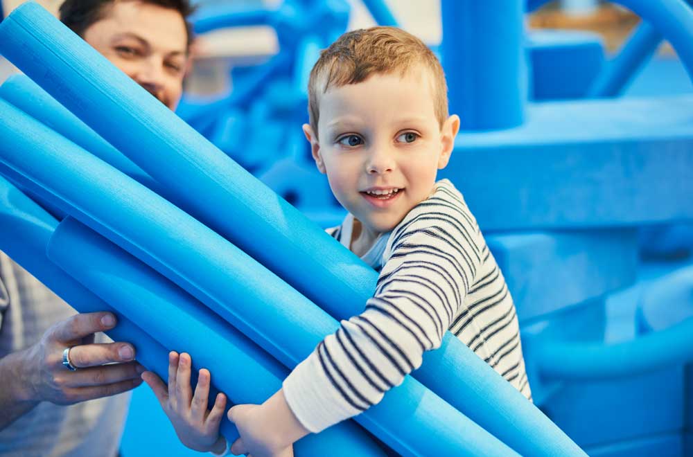 Enfant avec d’immenses morceaux de mousse bleus